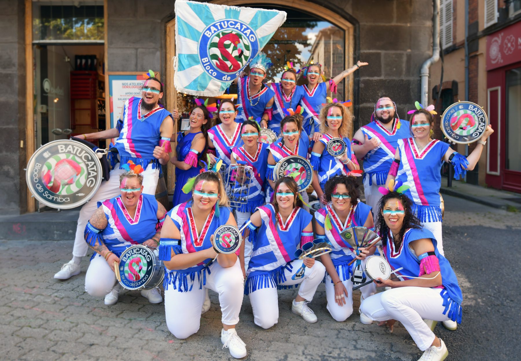 Les musiciens de BATUCATAG posent en costume bleu et blanc, instruments en main