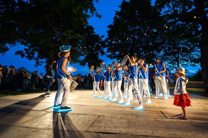La troupe en formation sur scène, au crépuscule