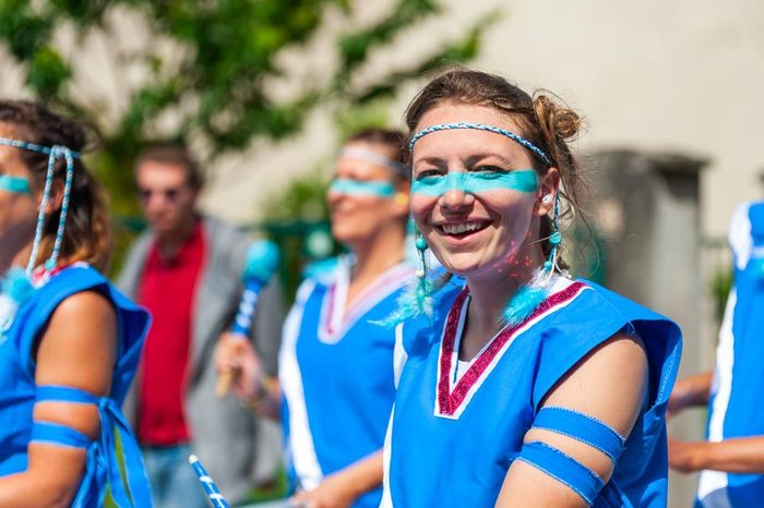 Une musicienne rit en jouant au milieu du public
