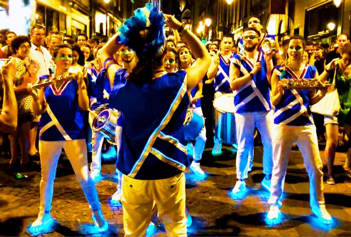 Le cortège illuminé avance dans une rue de nuit